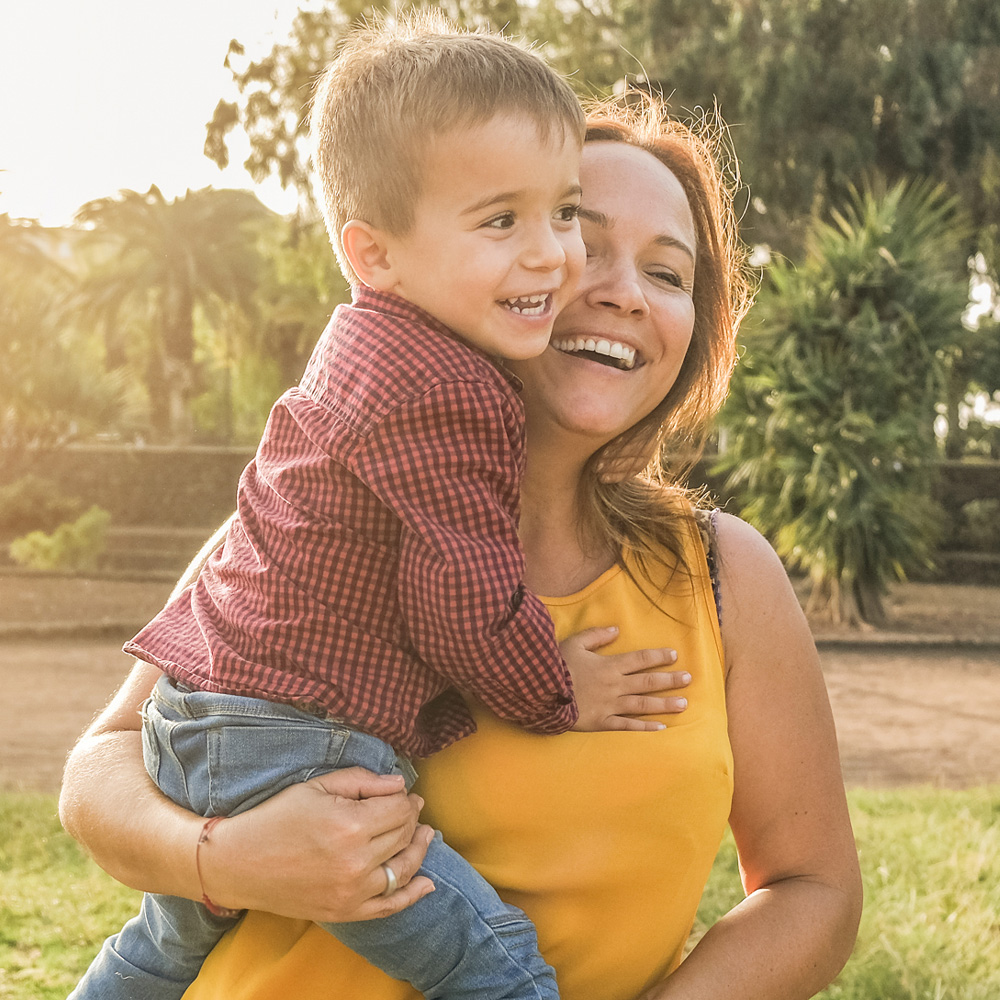 A mother holding her son outdoors, reflecting the strength and support of families served by MaaPaa
