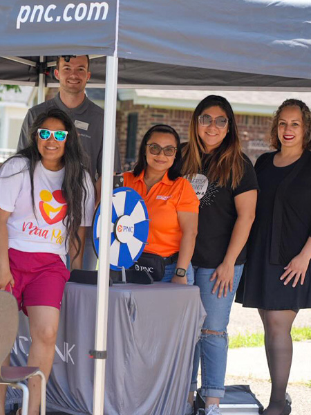 MaaPaa staff and community partners standing together at a summer kickoff event booth